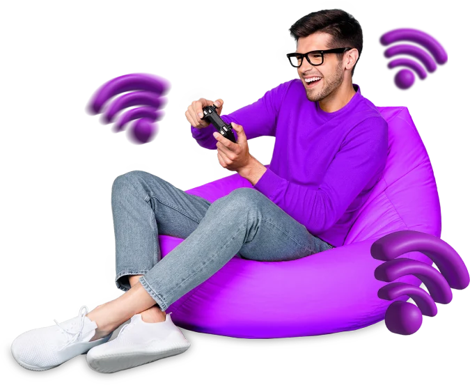 A man sitting on a purple bean bag playing game surrounded by wifi symbols.